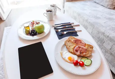 a table with two plates of food and a tablet at Via Villa Iliotti Rhodos in Rhodes Town