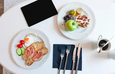 two plates of breakfast foods on a white table at Via Villa Iliotti Rhodos in Rhodes Town