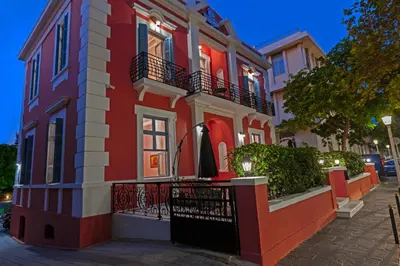 a red and white building with a black balcony at Via Villa Iliotti Rhodos in Rhodes Town