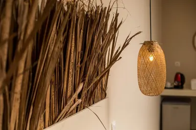 a wall with a painting of grass and a lamp at Atma Beach Rooms & Suites in Faliraki