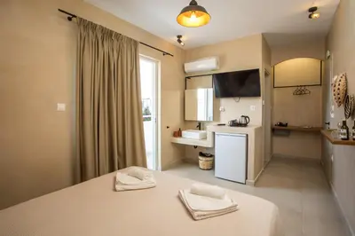 a room with a bed and a kitchen with a sink at Atma Beach Rooms & Suites in Faliraki