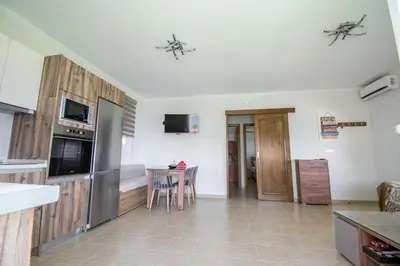 a kitchen with a table and a refrigerator and a counter at Golden sunrise stegna in Archangelos