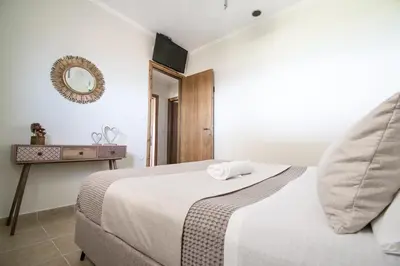 a bedroom with a bed and a mirror on the wall at Golden sunrise stegna in Archangelos