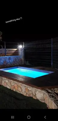 a swimming pool at night with blue lights at Golden sunrise stegna in Archangelos