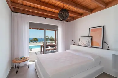a bedroom with a bed and a view of a pool at Terra d'Oro Sea view villa with private pool in Kiotari