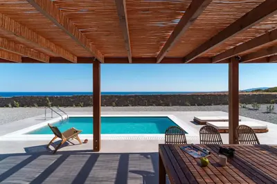 a view of a swimming pool from the deck of a house at Terra d'Oro Sea view villa with private pool in Kiotari