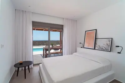 a bedroom with a bed and a view of the ocean at Terra d'Oro Sea view villa with private pool in Kiotari