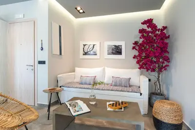 a living room with a couch and a vase of flowers at Elia & Anthos Deluxe Suites in Ixia