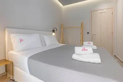 a bedroom with a large white bed with towels on it at Elia & Anthos Deluxe Suites in Ixia