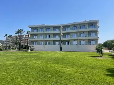 a building with a grass field in front of it at Ixia Dream hotel - Adults only in Ixia