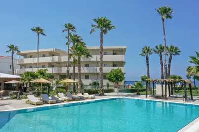 a swimming pool in front of a hotel with palm trees at Ixia Dream hotel - Adults only in Ixia