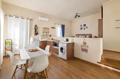 a small kitchen with a table and a refrigerator at Rementzo Apartment in Symi
