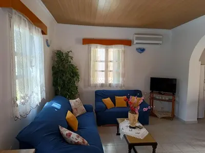 a living room with a blue couch and a table at Zoe Apartments in Symi