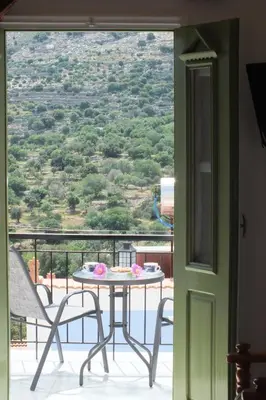 a table and chairs on a balcony with a view at Zoe Apartments in Symi