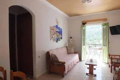 a living room with a couch and a window at Zoe Apartments in Symi