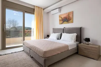a bedroom with a bed and a large window at Panthea Luxury Villa in Triánta