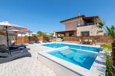 a villa with a swimming pool and a house at Panthea Luxury Villa in Triánta
