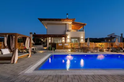 a villa with a swimming pool in front of a house at Panthea Luxury Villa in Triánta