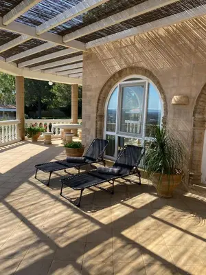 two black chairs on a patio with a window at Nostrana Village Apartments in Koskinou