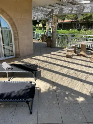 a patio with two chairs and a table in a building at Nostrana Village Apartments in Koskinou