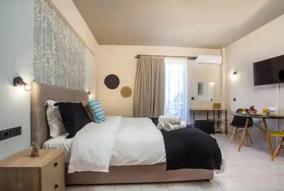 a bedroom with a bed and a table in it at Dorothea Apartments - Self-Catering Accommodation in Koskinou