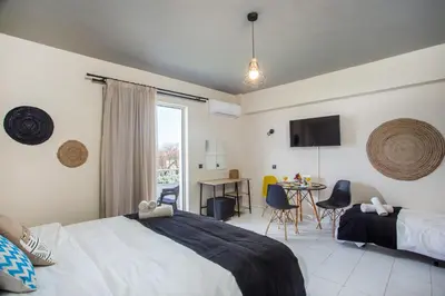 a bedroom with a bed and a table with chairs at Dorothea Apartments - Self-Catering Accommodation in Koskinou