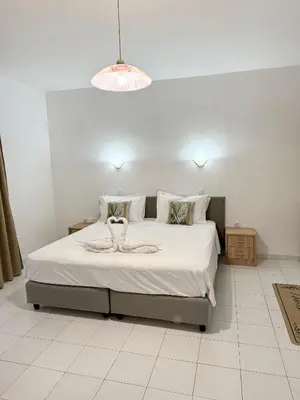 a bedroom with a large bed with white sheets and pillows at Dorothea Apartments - Self-Catering Accommodation in Koskinou