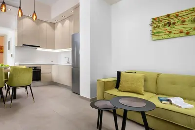 a living room with a couch and two tables and a kitchen at Onirico House in Rhodes Town