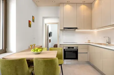 a kitchen with a wooden table and green chairs at Onirico House in Rhodes Town