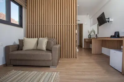 a living room with a couch and a television at Cactus Suites in Faliraki