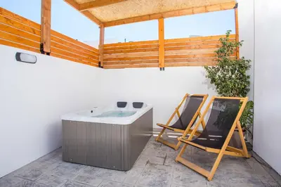 a bathroom with a bath tub and a chair at Cactus Suites in Faliraki