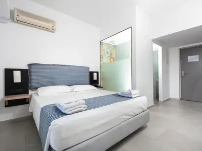 a bedroom with a large bed with towels on it at Lymberia Hotel in Faliraki