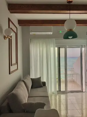 a living room with a couch and a view of the ocean at Skizenas Waterfront Apartments in Haraki