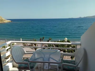 a table and chairs on a balcony overlooking the ocean at Skizenas Waterfront Apartments in Haraki