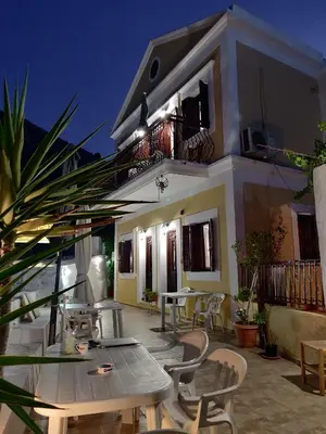 a patio with tables and chairs and a building at Nikos and Eva Studios in Symi