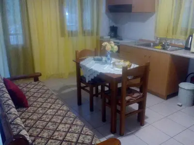 a kitchen with a table and chairs and a kitchen with a table and a kitchen at Nikos and Eva Studios in Symi