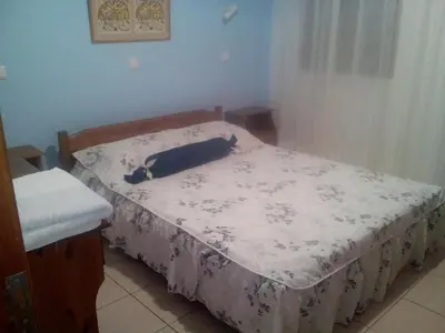 a small bedroom with a bed with a blue and white blanket at Nikos and Eva Studios in Symi