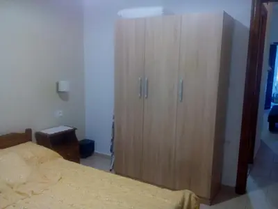 a bedroom with a large wooden cabinet next to a bed at Nikos and Eva Studios in Symi