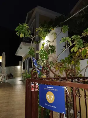 a sign in front of a building with plants at Nikos and Eva Studios in Symi