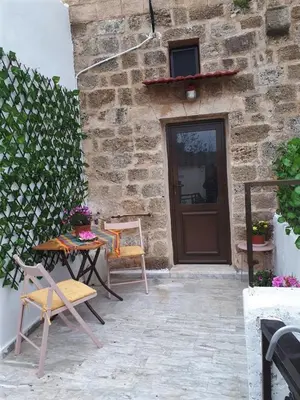 a patio with a table and chairs in front of a building at Traditional Stone house in Rhodes Town