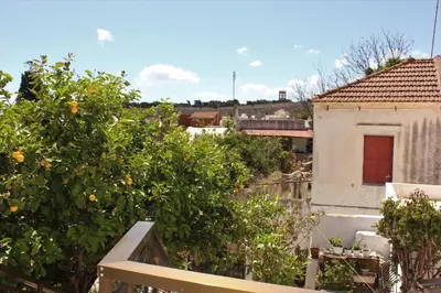 an orange tree in front of a building at Traditional Stone house in Rhodes Town