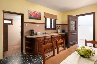 a kitchen with a sink and a table and chairs at Sea La Vie Villa Symi in Symi