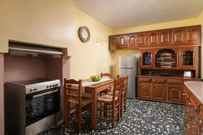 a kitchen with a table and chairs and a refrigerator at Sea La Vie Villa Symi in Symi