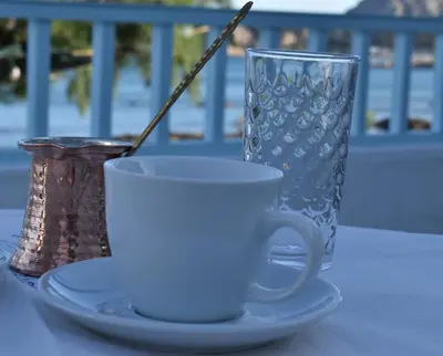 a coffee cup and a vase on a table at Casa al mare in Archangelos