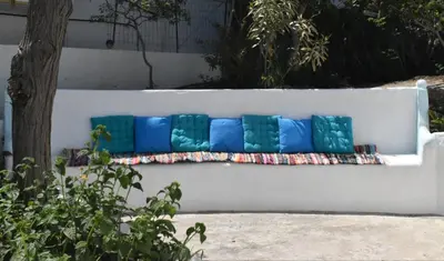 a white bench with blue pillows on it at Casa al mare in Archangelos