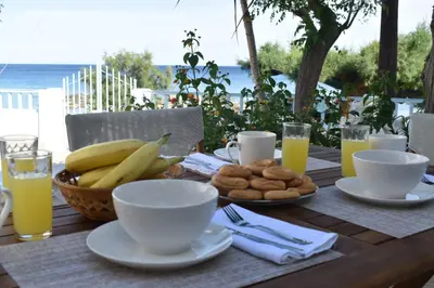 a wooden table with a breakfast of bananas and cookies at Casa al mare in Archangelos
