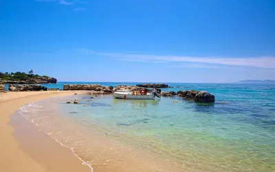 a boat in the water on a beach at Blue Line Villa Lindos in Líndos