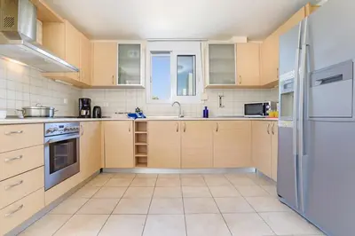 a kitchen with white appliances and wooden cabinets at Blue Line Villa Lindos in Líndos