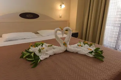 two swans made out of towels on a bed at Santa Helena Hotel in Ialyssos
