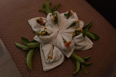 a towel with flowers on top of a table at Santa Helena Hotel in Ialyssos
